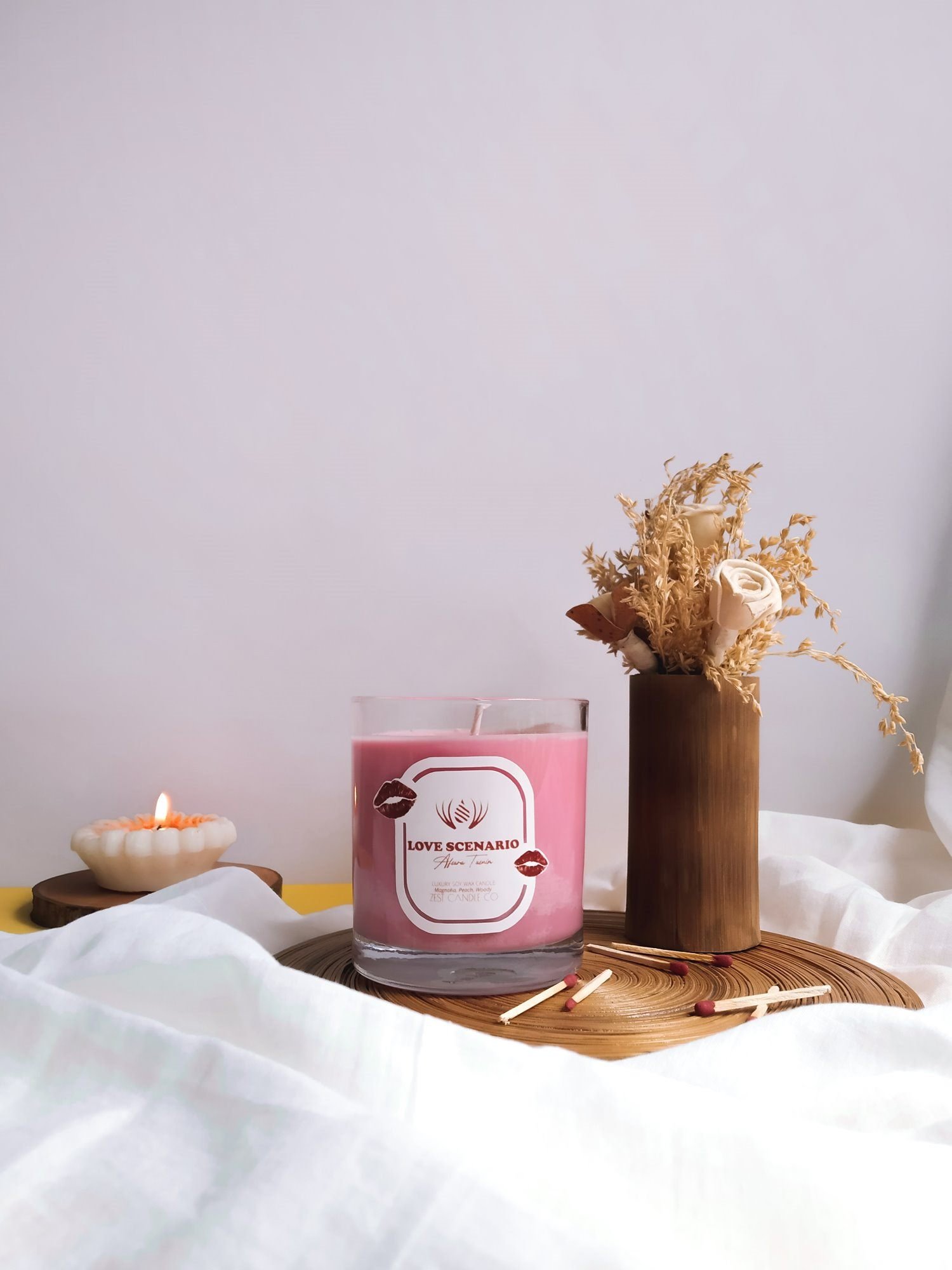 Love Scenario candle with its arched white label and lipstick-kiss marks.